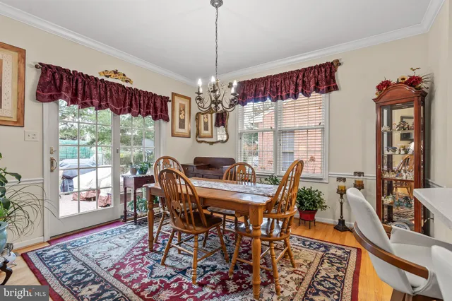 a dining room with furniture a chandelier and wooden floor