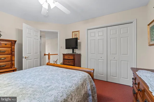 a bedroom with a bed and a flat tv screen on the dresser