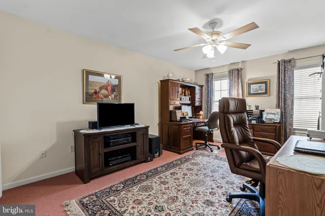 a view of a workspace with furniture and a window