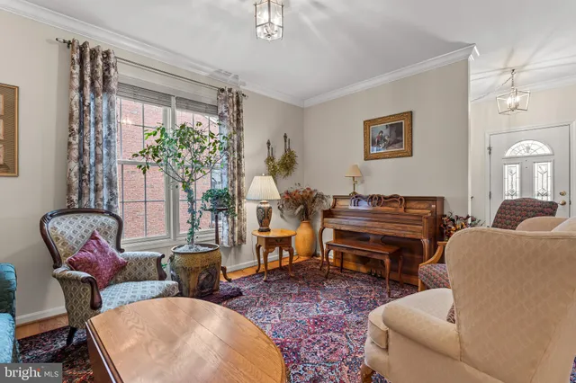 a living room with furniture a piano and a potted plant