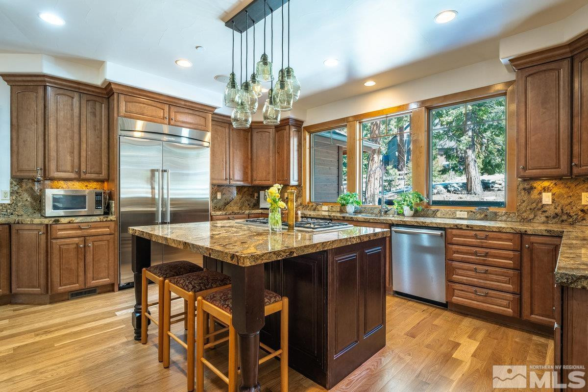 2147 The Back Road Glenbrook, NV 89413 - Photo 13 of 40 a kitchen with stainless steel appliances granite countertop a sink and a stove