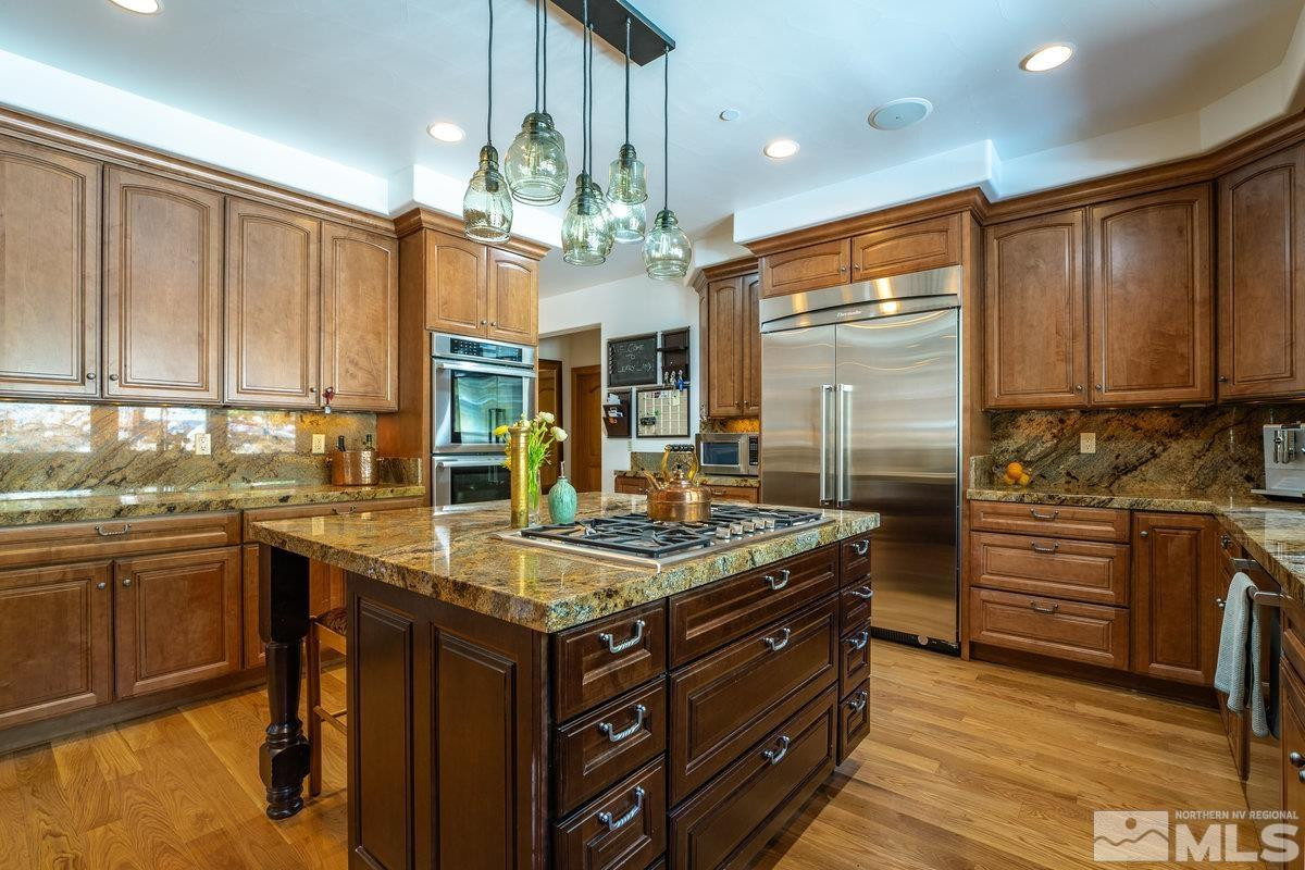 2147 The Back Road Glenbrook, NV 89413 - Photo 15 of 40 a kitchen with kitchen island granite countertop a sink cabinets and stainless steel appliances