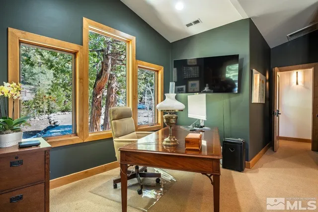 a view of a workspace with furniture and a window
