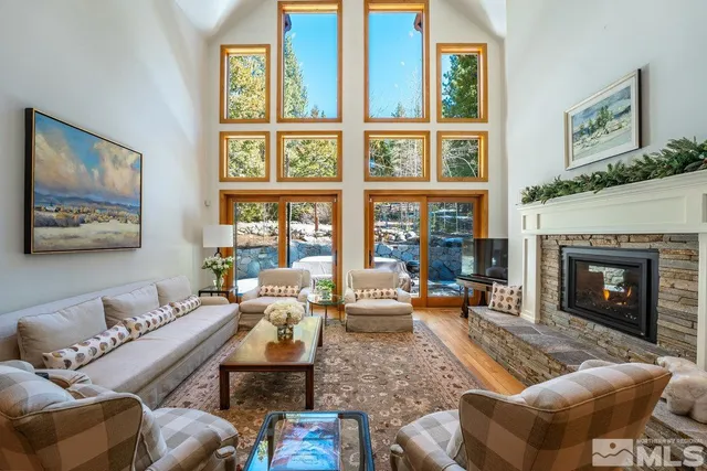 a living room with furniture large window and fireplace