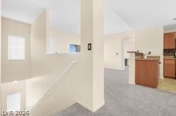 7701 West Robindale Road, Unit 277 Las Vegas, NV 89113 - Photo 4 of 33 A split-level interior with warm neutral tones and comfortable carpeted stairs.
