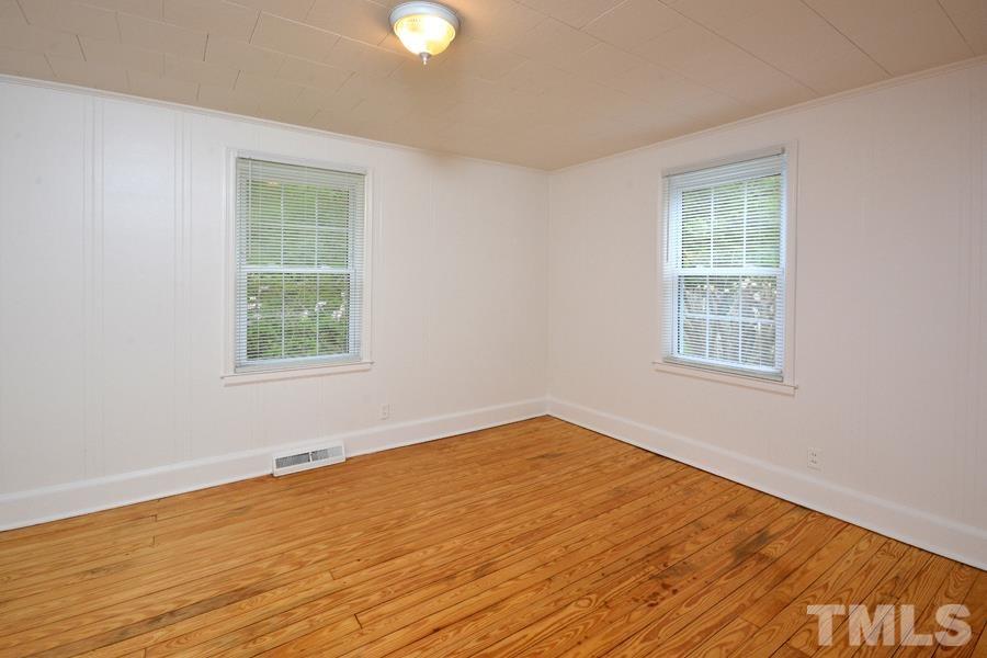 1703 Umstead Road Durham, NC 27712 - Photo 12 of 23 a view of an empty room with wooden floor and a window
