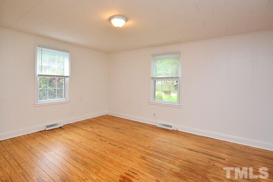 1703 Umstead Road Durham, NC 27712 - Photo 14 of 23 an empty room with wooden floor and windows
