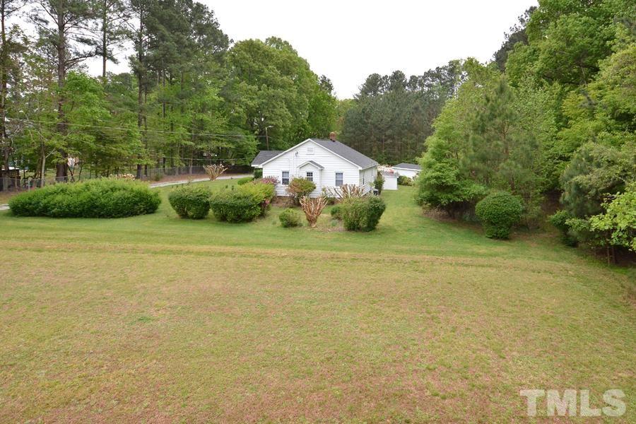 1703 Umstead Road Durham, NC 27712 - Photo 20 of 23 a front view of a house with a garden and yard