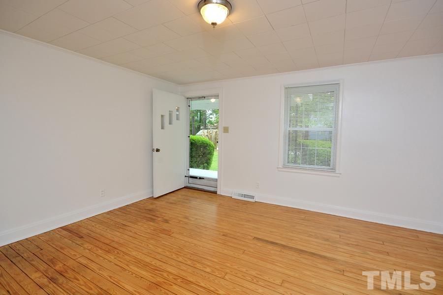 1703 Umstead Road Durham, NC 27712 - Photo 4 of 23 a view of an empty room with wooden floor and a window