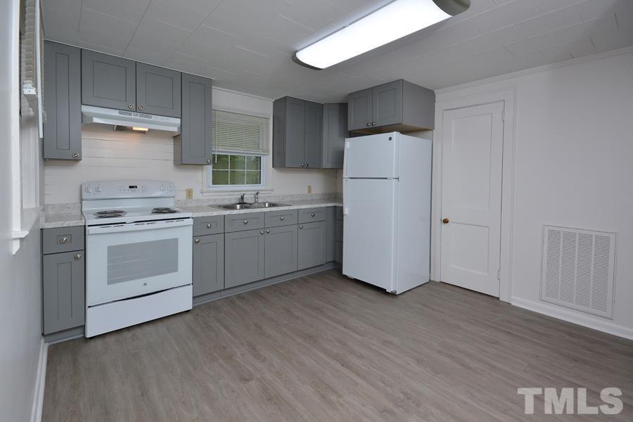 1703 Umstead Road Durham, NC 27712 - Photo 5 of 23 a kitchen with stainless steel appliances a sink cabinets and wooden floor