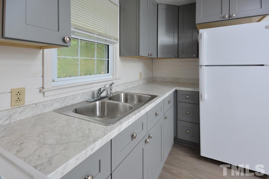 1703 Umstead Road Durham, NC 27712 - Photo 7 of 23 a kitchen with a sink dishwasher a refrigerator and cabinets