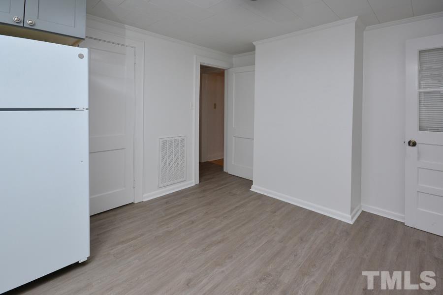 1703 Umstead Road Durham, NC 27712 - Photo 10 of 23 a view of an empty room with wooden floor and a refrigerator