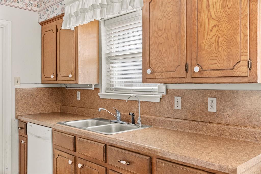 3013 Arapaho Road Commerce, TX 75428 - Photo 11 of 34 a kitchen with stainless steel appliances granite countertop white cabinets and a granite counter tops