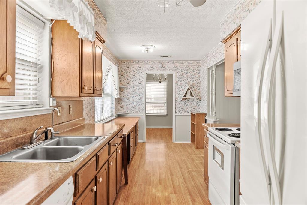3013 Arapaho Road Commerce, TX 75428 - Photo 13 of 34 a kitchen with stainless steel appliances granite countertop a sink stove and refrigerator