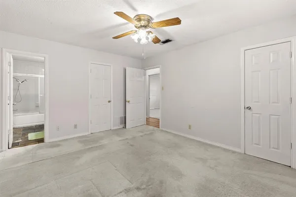 an empty room with closet and a chandelier fan
