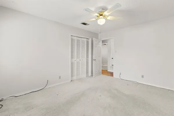 an empty room with a ceiling fan and a window