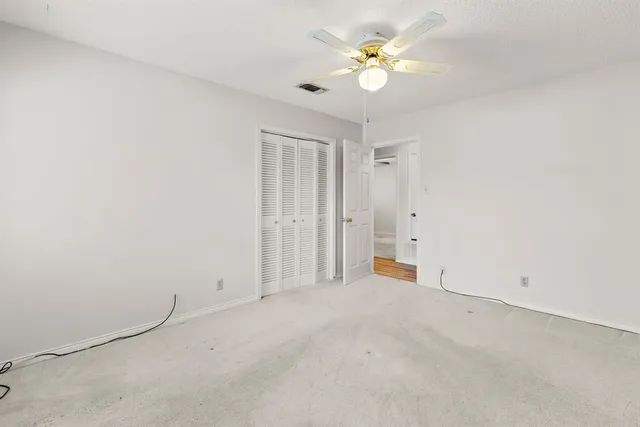 an empty room with a ceiling fan and a window