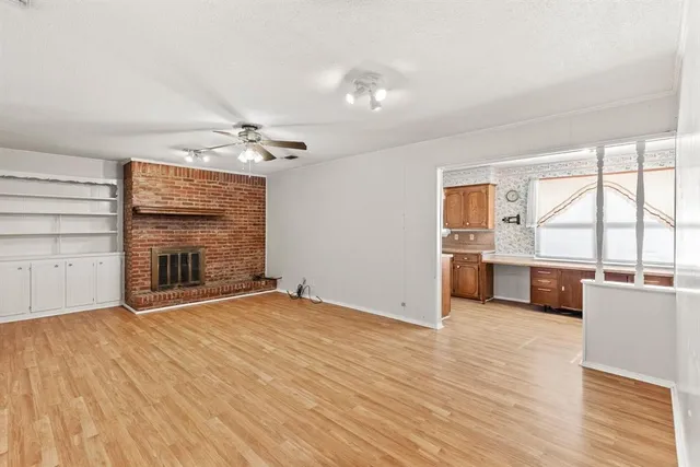 a view of a kitchen with a sink dishwasher and a fireplace