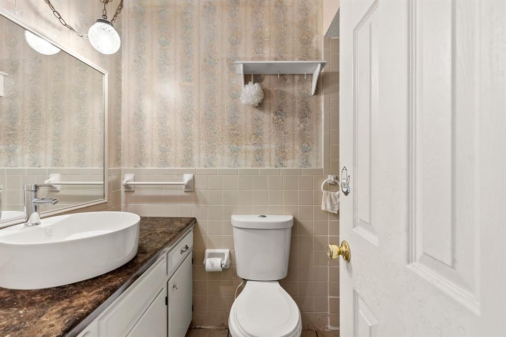 3013 Arapaho Road Commerce, TX 75428 - Photo 23 of 34 a bathroom with a toilet sink and mirror