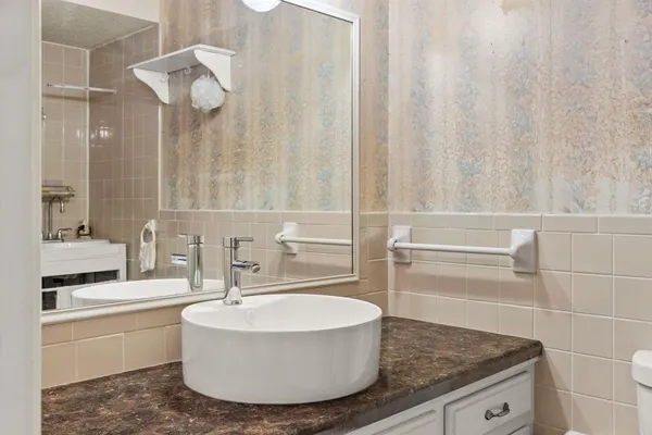 a bathroom with a granite countertop sink and a mirror