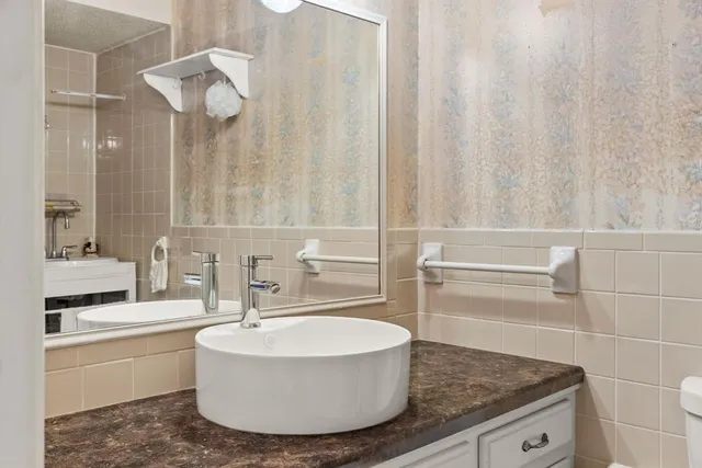 a bathroom with a granite countertop sink and a mirror