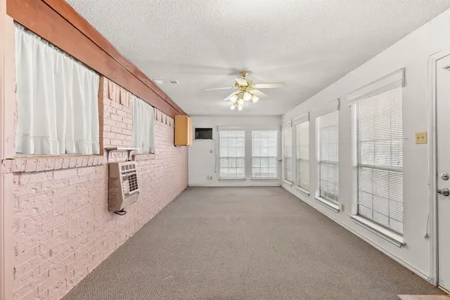 a view of a big room with windows and chandelier fan