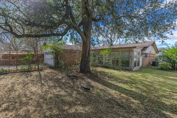 a view of a house with a yard and potted plants