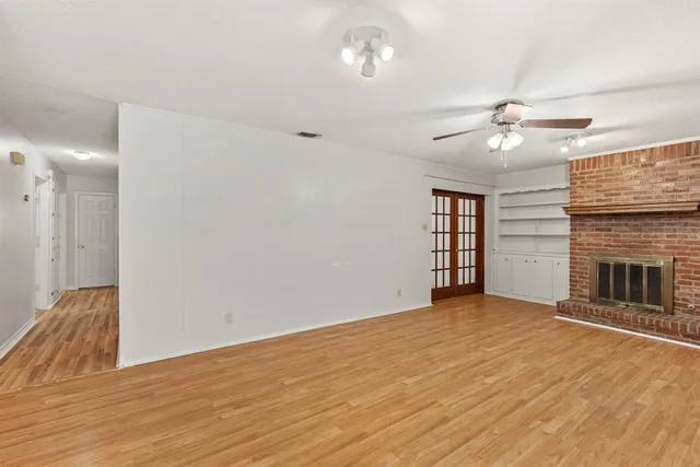 a view of empty room with a ceiling fan and wooden floor