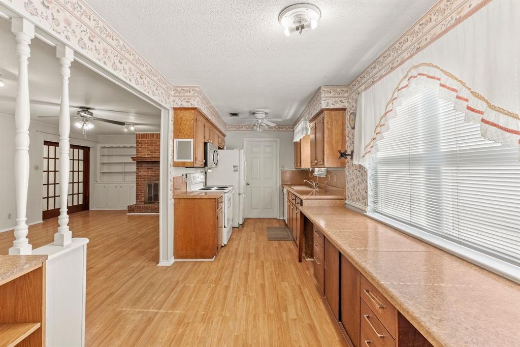3013 Arapaho Road Commerce, TX 75428 - Photo 9 of 34 a view of a kitchen with a sink and wooden floor