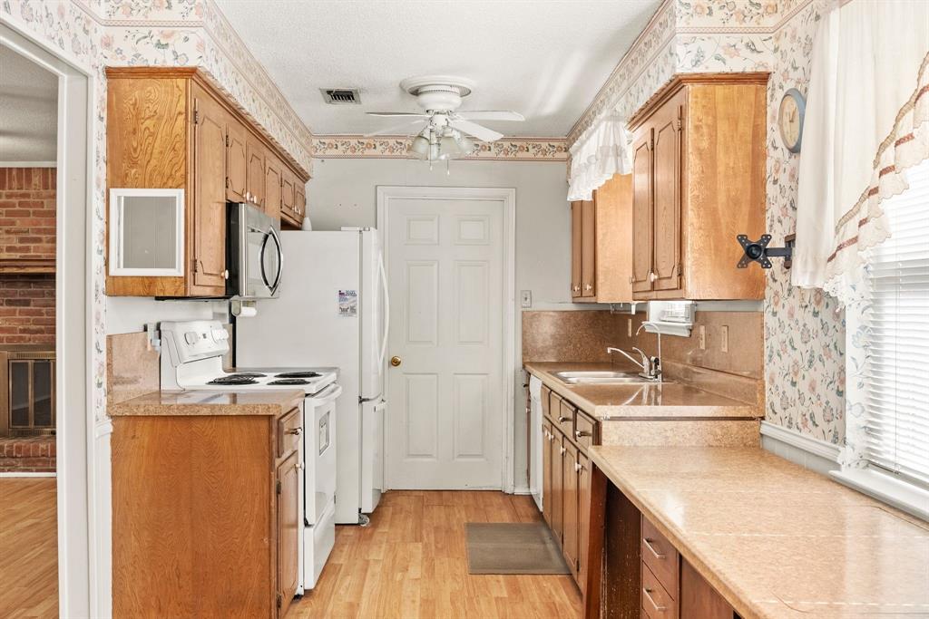 3013 Arapaho Road Commerce, TX 75428 - Photo 10 of 34 a kitchen with stainless steel appliances granite countertop a sink a stove and a refrigerator