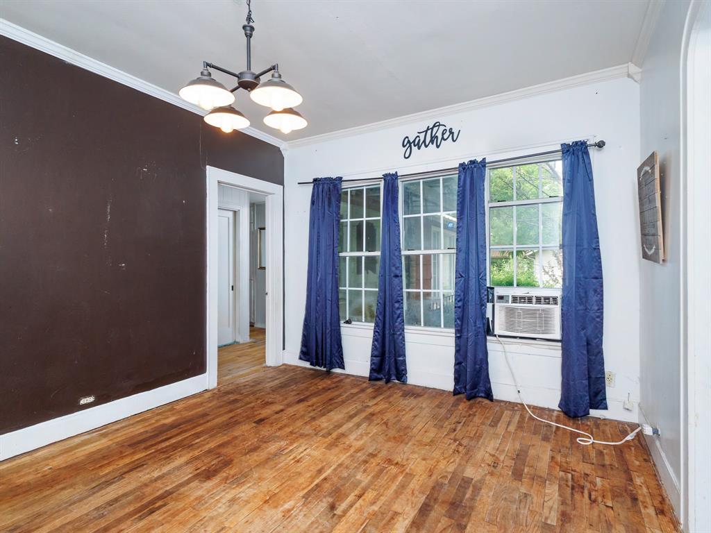 510 South Main Street Rising Star, TX 76471 - Photo 27 of 40 a bedroom with a bed and a chandelier