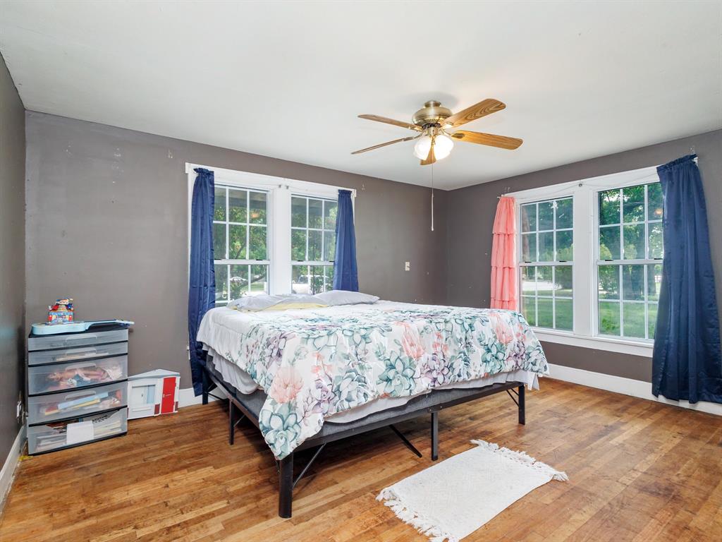 510 South Main Street Rising Star, TX 76471 - Photo 32 of 40 a bedroom with a bed and a chandelier