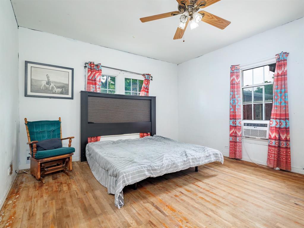510 South Main Street Rising Star, TX 76471 - Photo 35 of 40 a bedroom with a bed and a chandelier