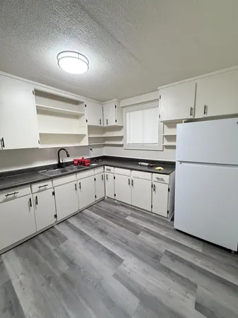 a view of a house with backyard and trees