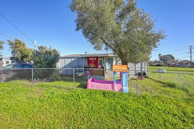 a front view of a house with a yard and trees