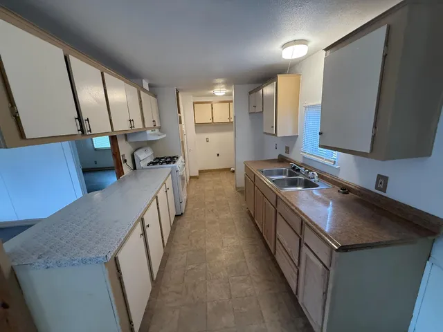 a kitchen with sink stove and cabinets
