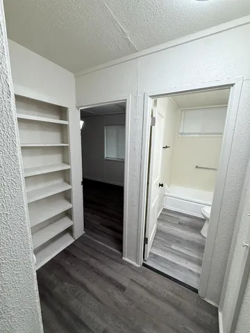 an empty room with wooden floor and white doors