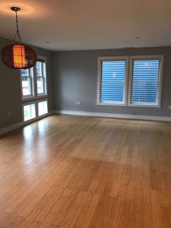 2 Boylston Street, Unit 3 Boston, MA 02130 - Photo 3 of 9 a view of an empty room with wooden floor and a window