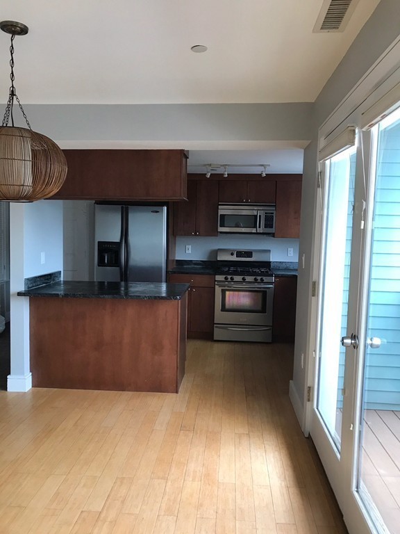 2 Boylston Street, Unit 3 Boston, MA 02130 - Photo 4 of 9 a kitchen with stainless steel appliances granite countertop a stove a sink and a refrigerator