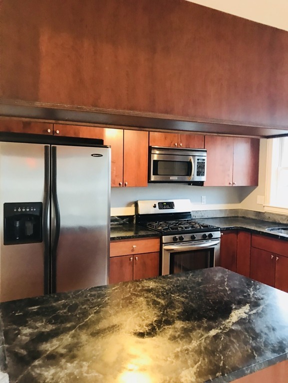 2 Boylston Street, Unit 3 Boston, MA 02130 - Photo 6 of 9 a kitchen with stainless steel appliances granite countertop a refrigerator a stove a sink and a microwave
