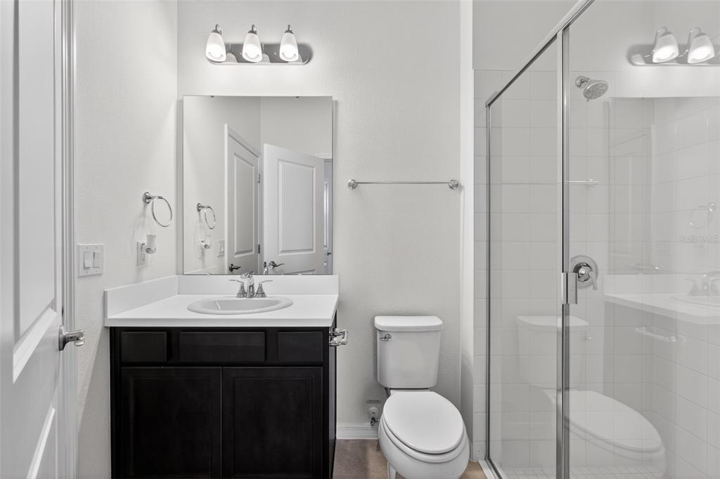 810 MIDDLETON Street DeBary, FL 32713 - Photo 45 of 52 a bathroom with a toilet a sink a mirror a vanity and shower