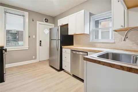 a kitchen with white cabinets and refrigerator