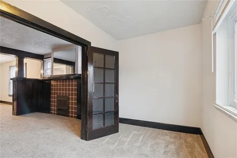 an empty room with fireplace and windows