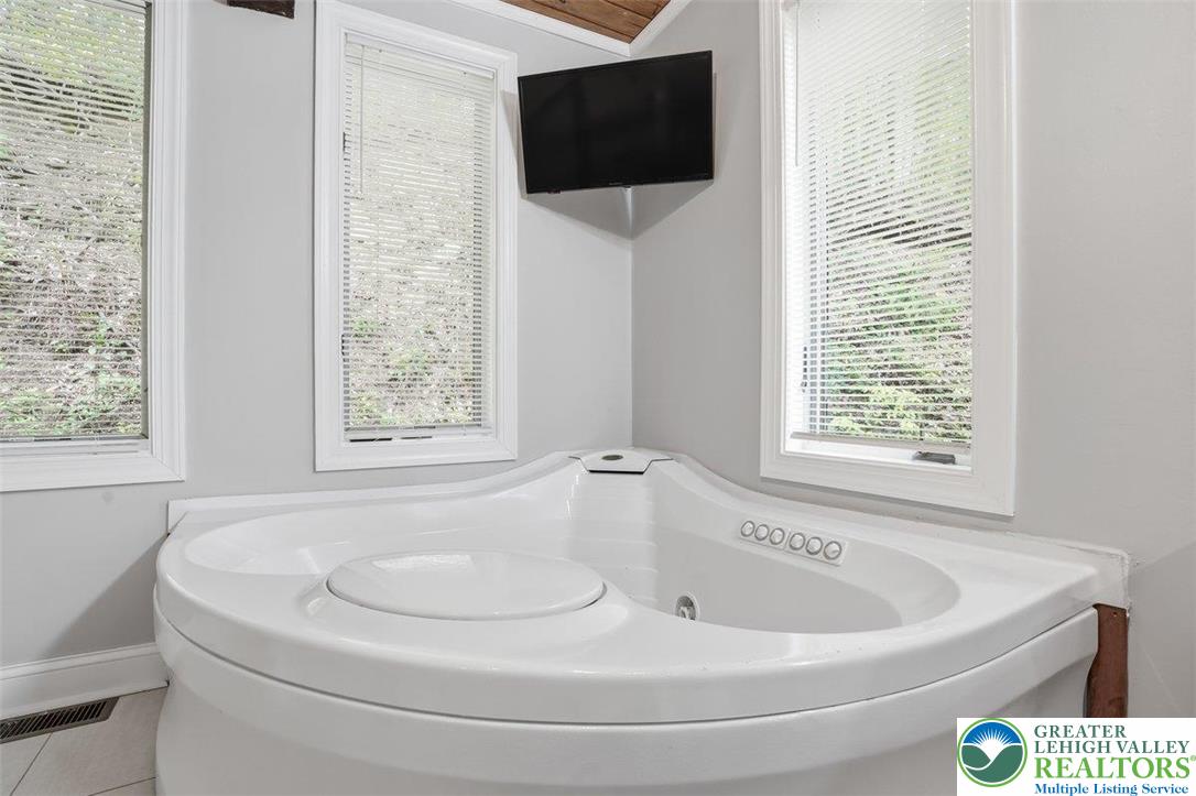 2288 Mulberry Road Fogelsville, PA 18051 - Photo 12 of 35 a bathroom with a bathtub and flat screen tv
