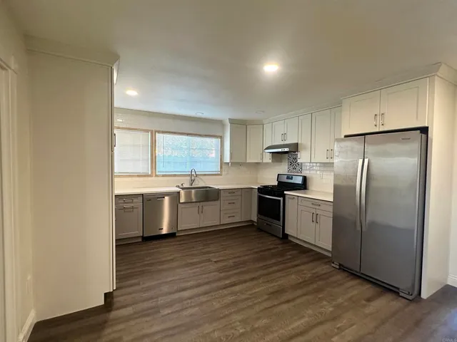 a kitchen with a refrigerator and a stove top oven