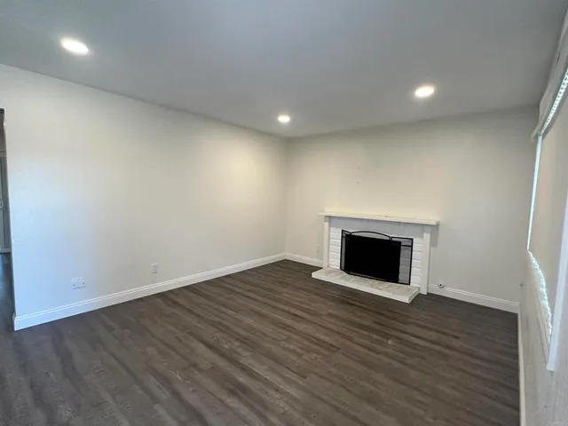 an empty room with wooden floor and fireplace