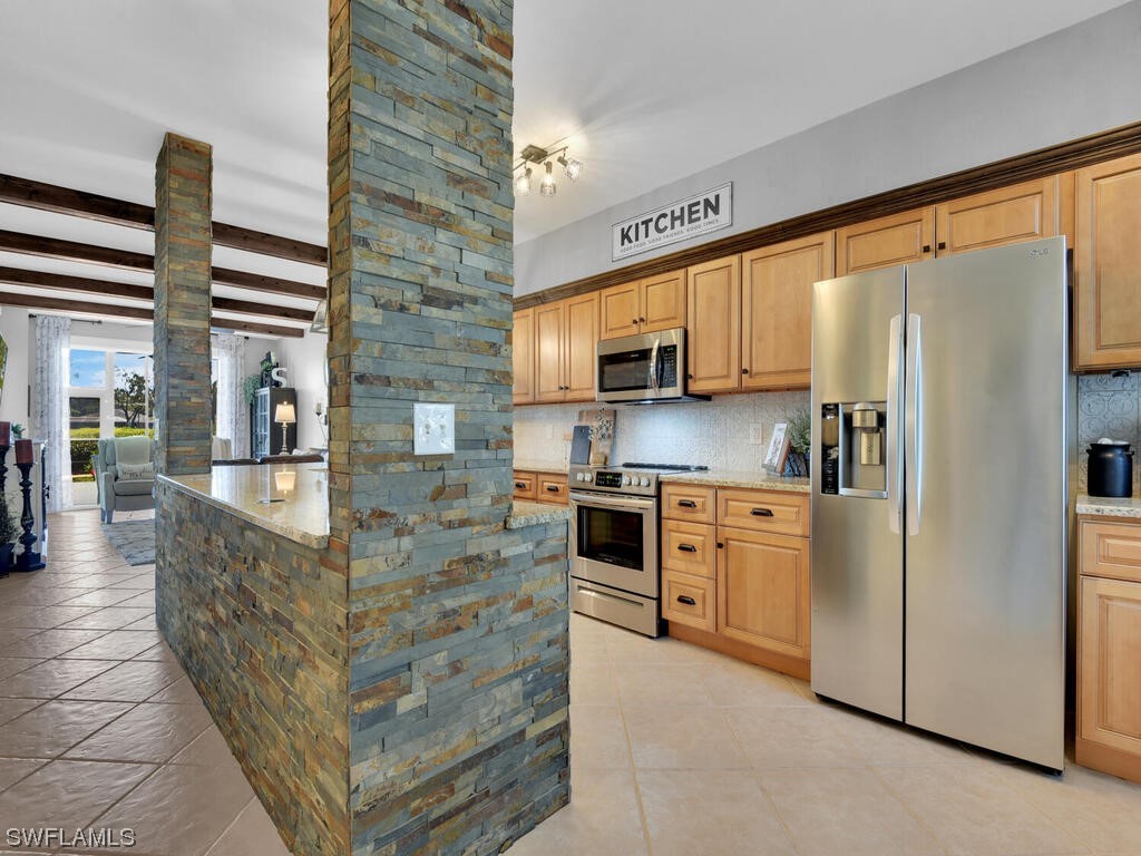 a kitchen with stainless steel appliances granite countertop a refrigerator a stove and a sink with cabinets