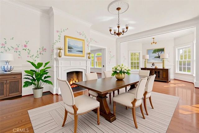 a view of an empty room with wooden floor and a chandelier
