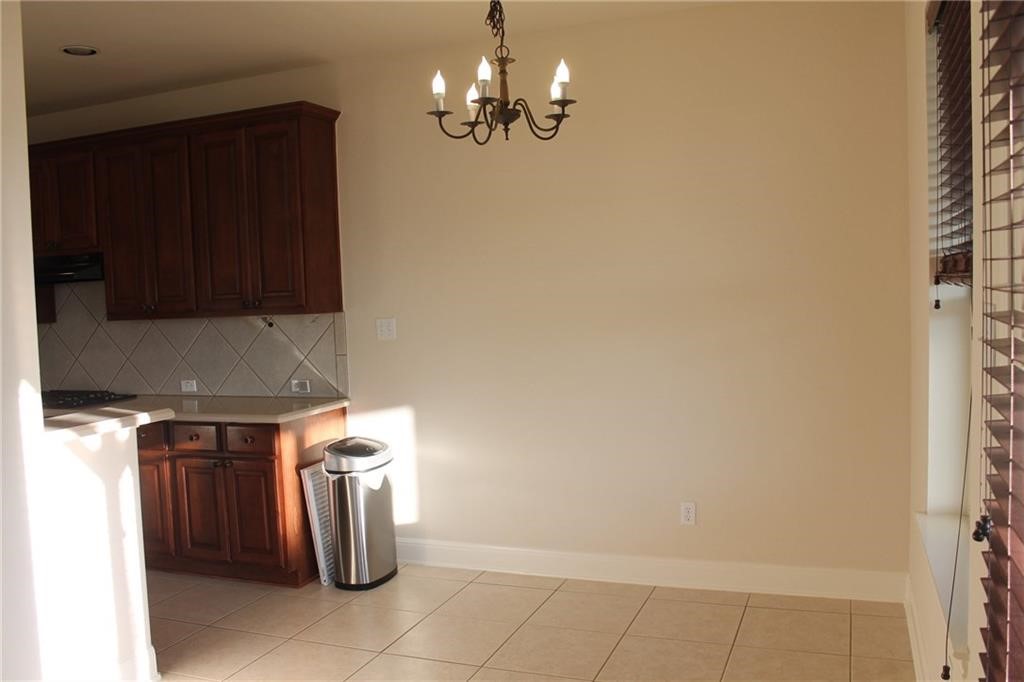 2513 Rusk Court Round Rock, TX 78665 - Photo 13 of 39 Kitchen featuring light countertops, pendant lighting, backsplash, a chandelier, and light tile patterned floors