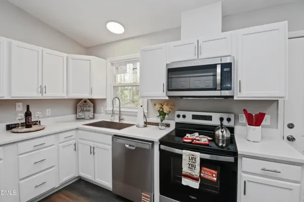a kitchen with granite countertop a refrigerator stove top oven and sink